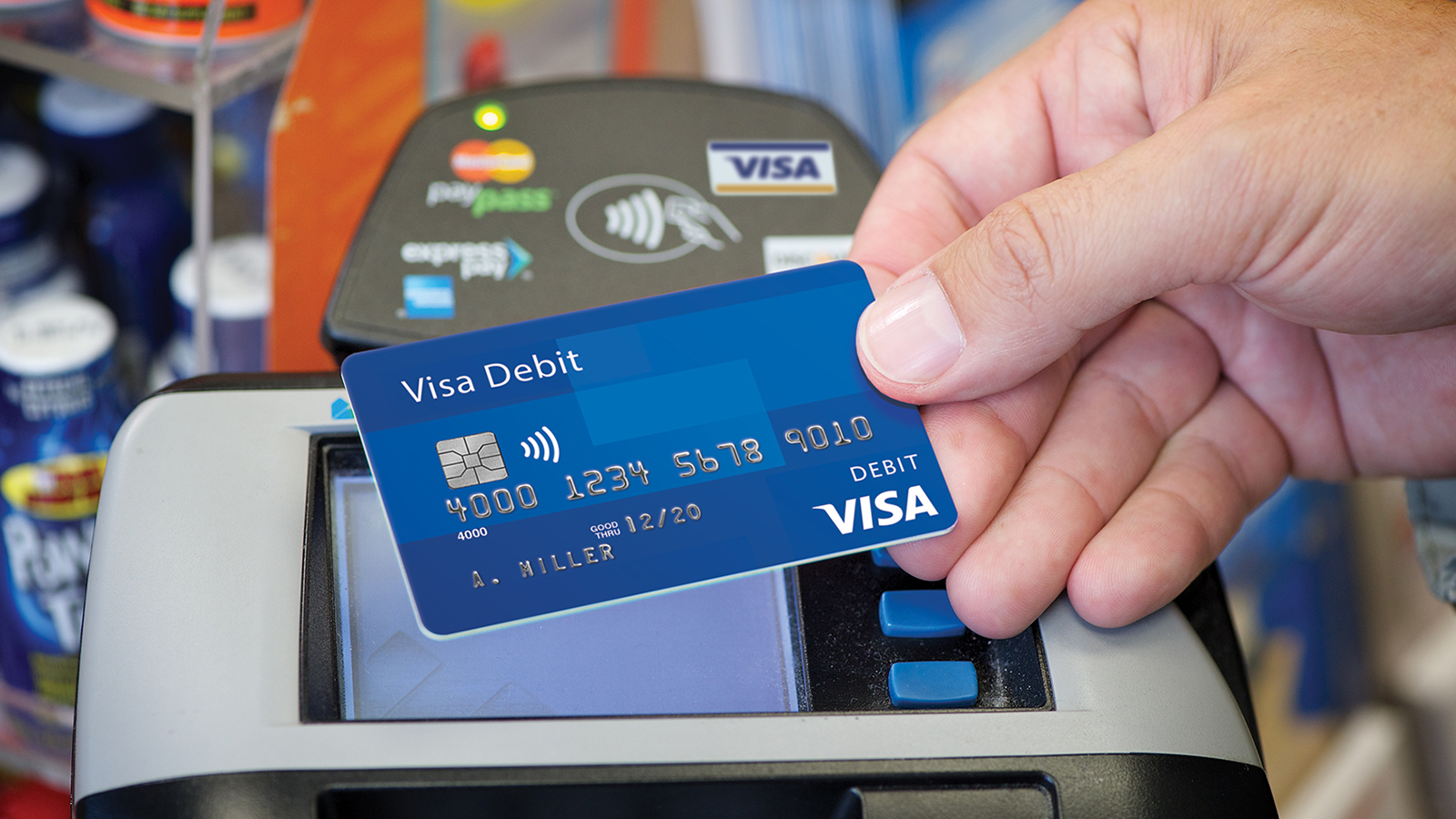 Presenting a contactless Visa debit card at checkout.
