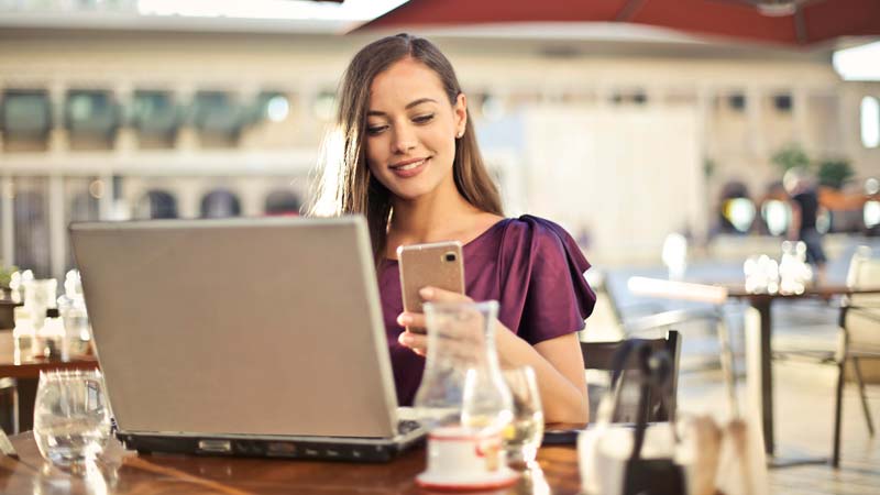 Woman using laptop and mobile