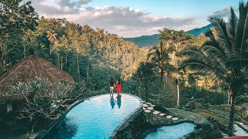 Gambar pasangan yang menikmati keindahan alam dsialah satu resort pada sat travel ke Bali 
