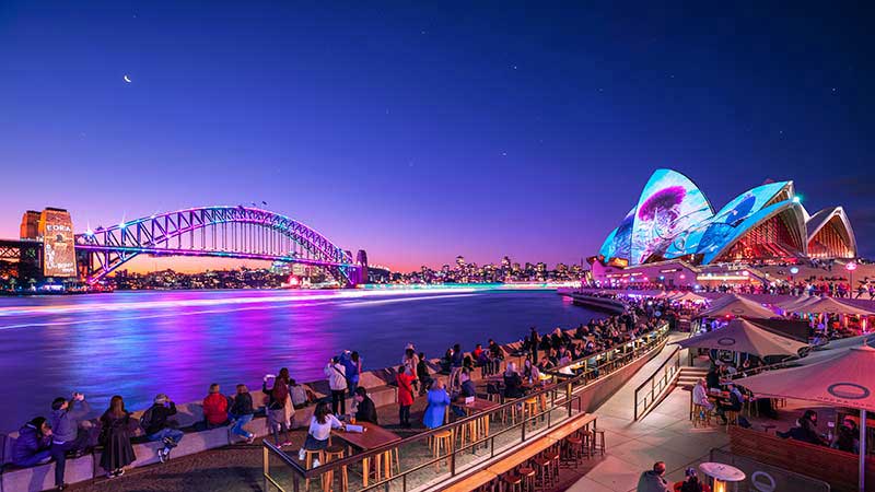 Gambar suasana malam hari dekat Sydney Opera House dan bisa menikmati makanan lokal dengan menggunakan kartu kredit Australia