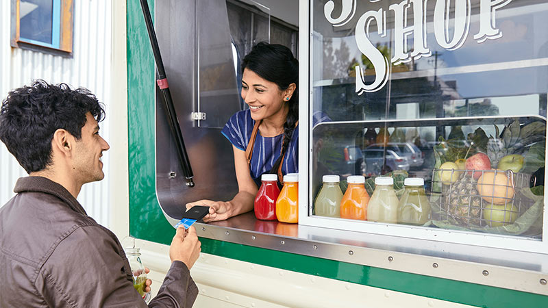 man paying using card at a juice store